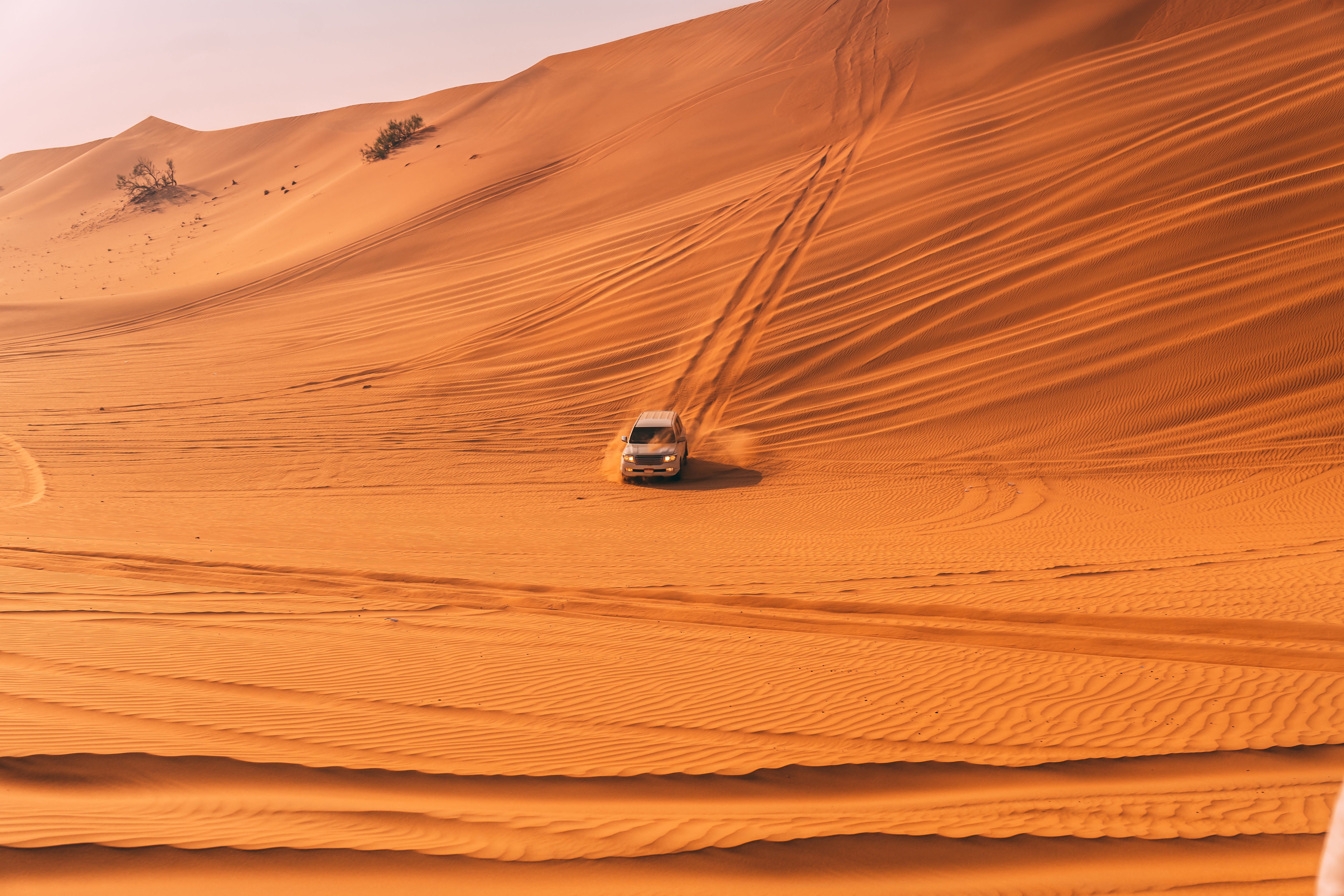 Four-wheel drive vehicle dune bashing in the desert