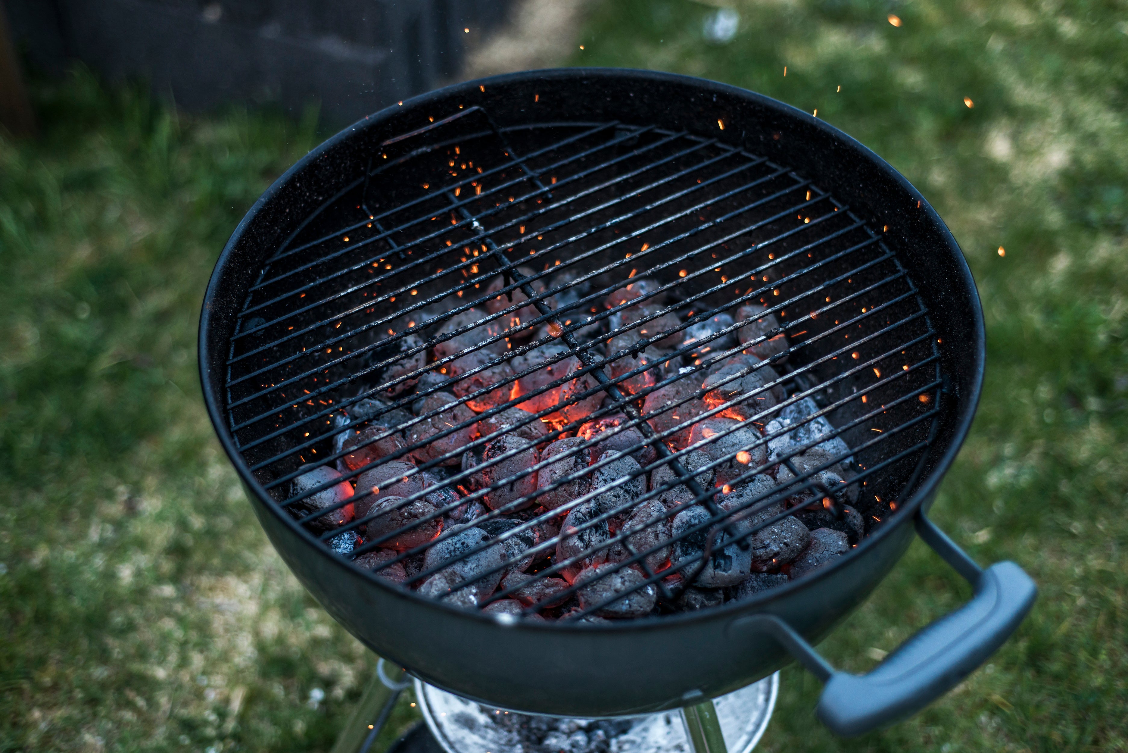 Glowing hot charcoal briquettes on a barbecue grill